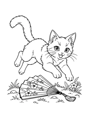 A playful cat leaps over an open folding fan among small flowers and grass.